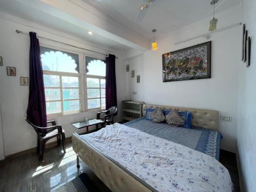 a bedroom with a bed and a large window at Boraj Haveli Guest House in Udaipur