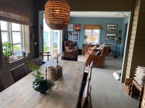 a dining room with a table and a living room at Villa Borgvåg - A unique Seafront Villa in the heart of Lofoten in Bøstad