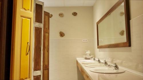 een badkamer met 3 wastafels en een spiegel bij FINCA ALEGRANZA in Torrelavega