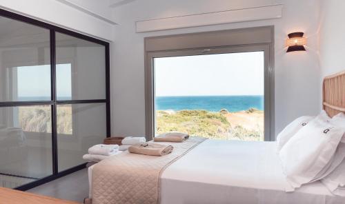Alykes Beachside Stylish Villas with Private Pool South Rhodes في لاخنيا: غرفة نوم مع سرير وإطلالة على المحيط