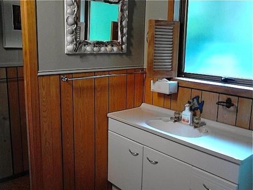a bathroom with a sink and a mirror at The Great Escape - Tairua Holiday Home in Tairua