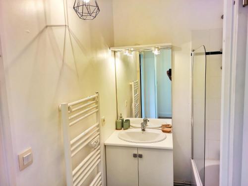 uma casa de banho com um lavatório e um espelho em L'Ebenisterie - Sublime Type 2 Lumineux - Grand balcon em Orvault