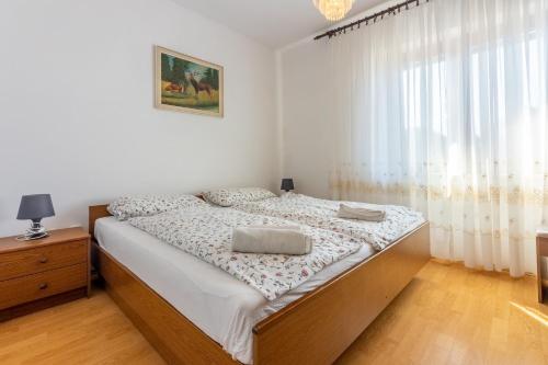 ein Schlafzimmer mit einem Bett und einem großen Fenster in der Unterkunft Apartment Vazmica in Punat
