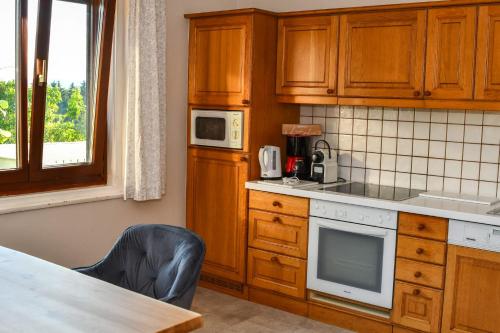 eine Küche mit Holzschränken, einem Tisch und einem Stuhl in der Unterkunft Haus Christoph in Winklern
