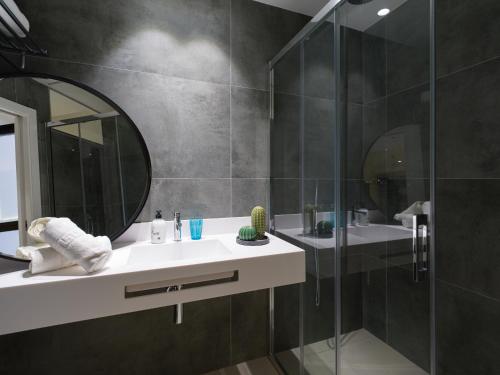 a bathroom with a sink and a shower with a mirror at Hotel MG Poniente in Las Palmas de Gran Canaria