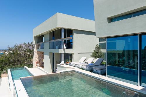 uma casa com uma piscina em frente em Villa Charlotte by Cura Villas Collection em Kalathas