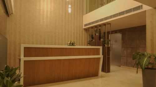 a lobby with a reception desk and plants at Florida Airport Hotel Kochi in Nedumbassery