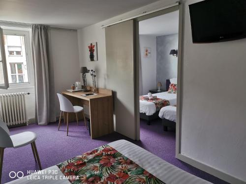 a room with two beds and a desk with a mirror at Hotel Des Négociants in Lamastre