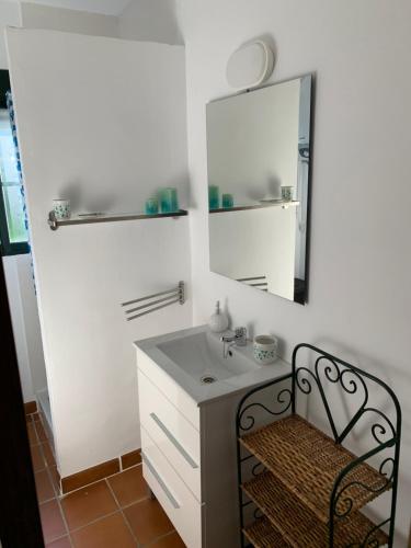 a bathroom with a sink and a mirror and a chair at Finca Dos Vientos Tarifa in Tarifa