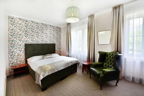 A bed or beds in a room at APLEND Hotel Lujza Major