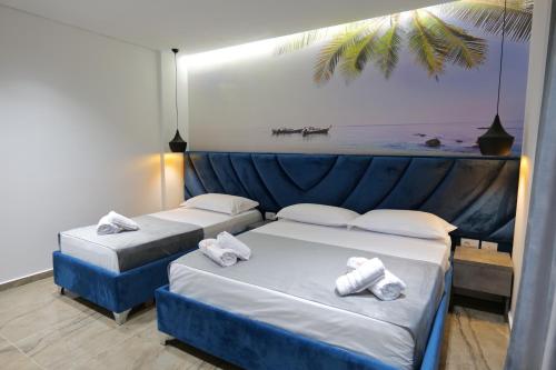 two beds in a hotel room with towels on them at Hotel Eagle in Ksamil