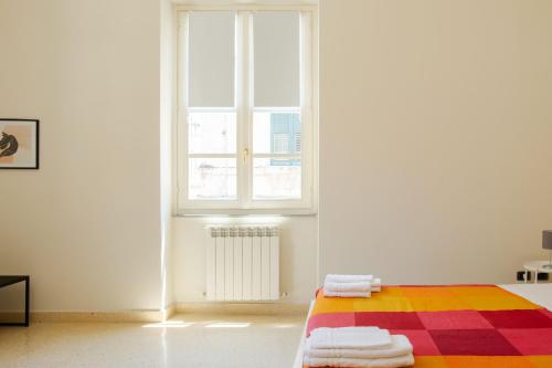 a white room with a bed and a window at Corner Cavour Apartment in Sassari