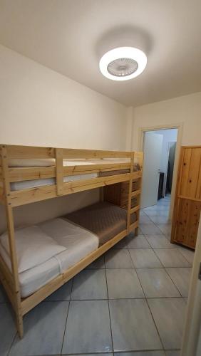 a room with wooden bunk beds on a tile floor at Residenza La Gazza e Spiaggia in Cervia