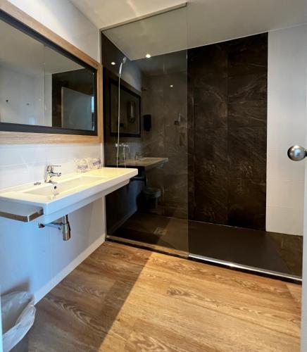 a bathroom with a sink and a shower at Hotel Hey Peñíscola in Peniscola