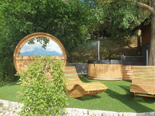 a group of benches sitting on the grass in a garden at Chatka Panorama in Mlynčeky