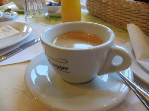 a cup of coffee on a plate on a table at Hotel Kleißl in Oberperfuss