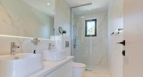 biała łazienka z umywalką i prysznicem w obiekcie Villa Delphin 375 Fantastic villa with amazing outside space, Aphrodite Hills w mieście Kuklia