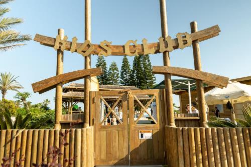 a wooden fence with a wooden entrance to a playground at AQI Pegasos World in Side