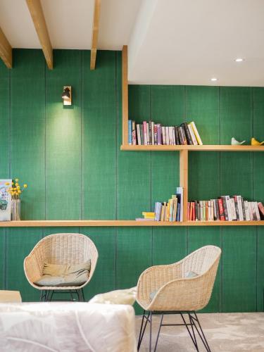 two chairs in a room with a green wall at Best Western Le Bois de la Marche in Poitiers