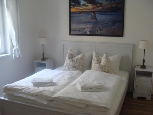 ein weißes Bett mit zwei Handtüchern darüber in der Unterkunft Goetheresidenz Bad Saarow in Bad Saarow