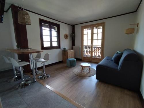 a living room with a couch and a table at Chalet Appart'Hôtel l'Eau Vive in Saint-Nicolas-la-Chapelle