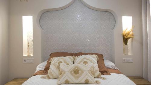 a bed with a white headboard and two pillows on it at Apartamento ruh sara by Toledo AP in Toledo