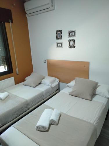 two beds in a room with towels on them at New Hortaleza Coliving in Madrid