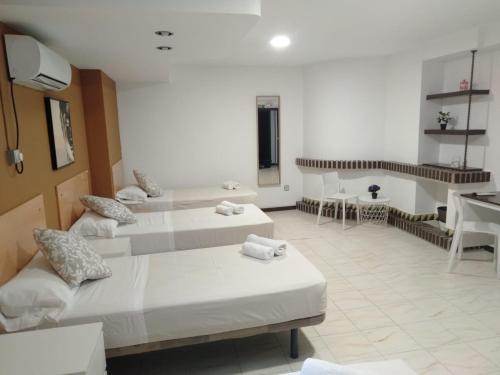 Habitación con 2 camas, mesa y sillas en New Hortaleza Coliving, en Madrid