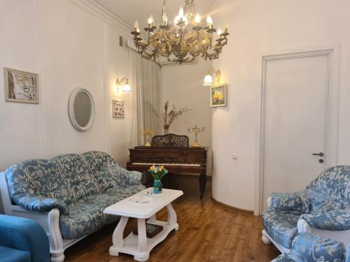 a living room with two couches and a table and a piano at Lowell Hotel in Tbilisi City