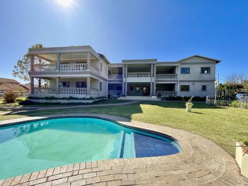 a large house with a swimming pool in front of it at Atlantic Pearl Guest House Midrand in Midrand