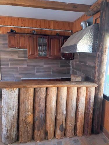 a kitchen with a bar made out of logs at Kuća za odmor/Party kuća in Lukinić Senovec