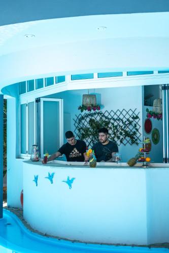 two men standing at a counter in a blue kitchen at RODI BLUE apartments in Amoudara Herakliou