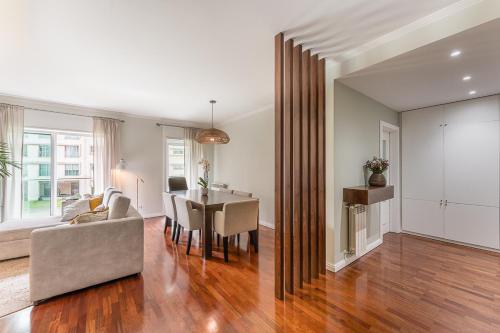 a living room with a table and a couch and a dining room at Beachfront Apartment in Matosinhos