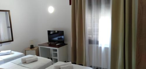 a hotel room with two beds and a television at New Hortaleza Coliving in Madrid