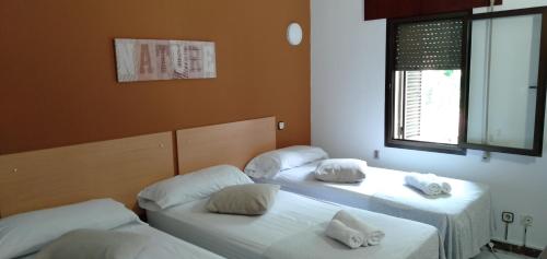 three beds in a room with white pillows on them at New Hortaleza Coliving in Madrid