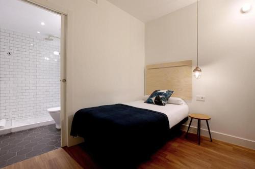a bedroom with a bed and a bathroom with a toilet at Magatzem 128 in Barcelona