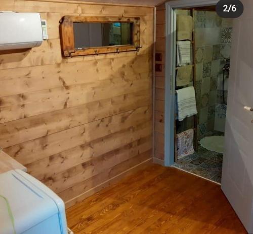 a bathroom with a wooden wall with a mirror at CASA DI PATOURIA , stenies Andros in Andros