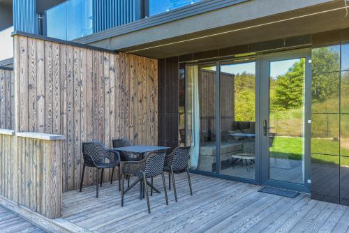 a patio with chairs and a table on a deck at VAIVA Apartments, Palanga in Šventoji
