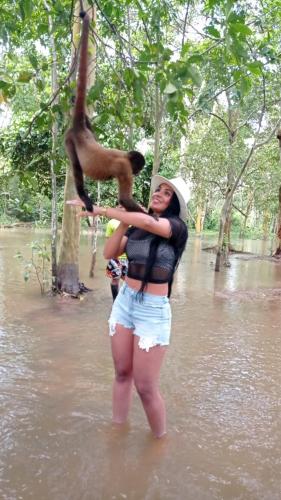 a woman standing in the water with a monkey on her back at Milía Amazon Lodge in Iquitos
