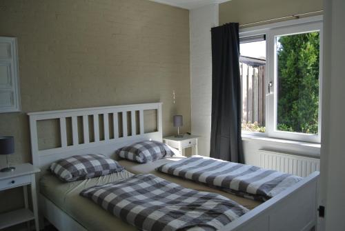 two beds in a bedroom with a window at Duinnest in Noordwijkerhout