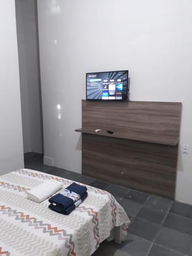 sypialnia z łóżkiem i telewizorem na komodzie w obiekcie SUÍTE Nº 4 - próximo a feira da sulanca caruaru-PE w mieście Caruaru