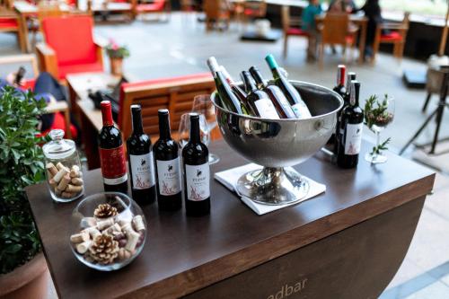 a table with bottles of wine and a metal bowl of wine bottles at Hyatt Regency Bishkek in Bishkek