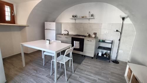 een keuken met een witte tafel en een witte koelkast bij Casetta Tipica in Borgo, indipendente, ristrutturata in LʼAquila