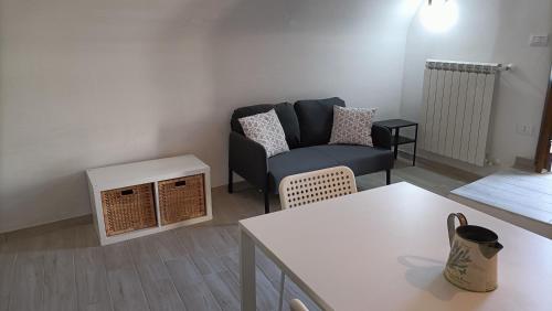 een woonkamer met een bank en een tafel bij Casetta Tipica in Borgo, indipendente, ristrutturata in LʼAquila