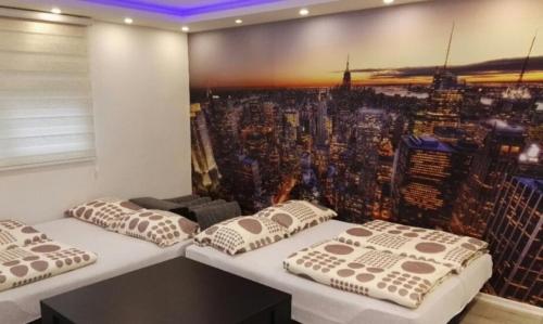 two beds in a room with a picture of a city at Istočno Sarajevo in Sarajevo