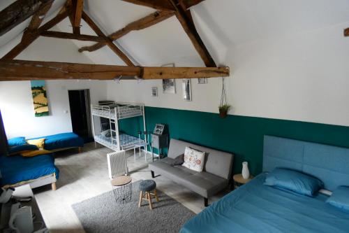 - une chambre avec un lit bleu et un canapé dans l'établissement Le Héron bleu de la Brenne, à Tournon-Saint-Martin