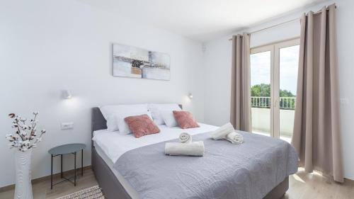 een witte slaapkamer met een bed en een groot raam bij Villa Oliveti by Villas Holiday in Frata