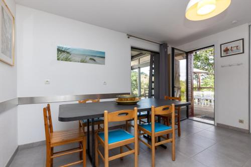 une salle à manger avec une table et des chaises noires dans l'établissement Bousquet Villa Vue Exceptionnelle, à Moliets-et-Maa