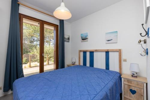 Un dormitorio con una cama azul y una ventana. en Bousquet Villa Vue Exceptionnelle, en Moliets-et-Maa