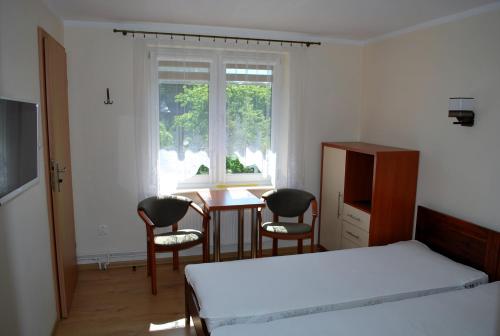 1 dormitorio con 1 cama, mesa y sillas en Pokoje Gościnne Beata en Wisełka
